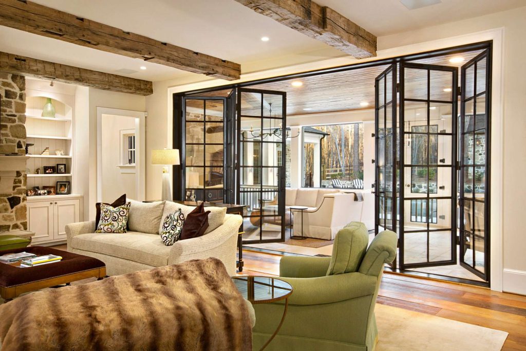 bifold steel glass doors open separating living room & outdoor sunroom recess lighting exposed beams