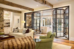 bifold steel glass doors open separating living room & outdoor sunroom recess lighting exposed beams
