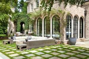 exterior of brick home with overgrown plants on black steel windows and doors